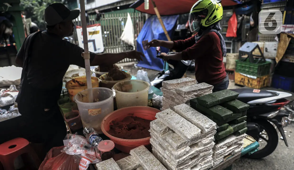 Penjual tempe melayani pembeli di Pasar Kebayoran Lama, Jakarta, Selasa (15/2/2022). Tempe dan tahu akan hilang di pasar tradisional dikarenakan kenaikan harga kedelai saat ini sudah di atas kewajaran. (Liputan6.com/Johan Tallo)