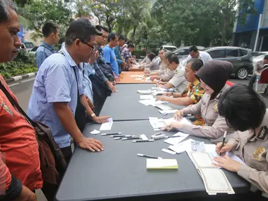Petugas mendata pengurusan BPKB di Gedung Biru Ditlantas Polda Metro Jaya, Jakarta, Kamis (5/1). Antrean tersebut terjadi jelang kenaikan biaya PNBP (penerimaan negara bukan pajak) dalam pengurusan administrasi kendaraan. (Liputan6.com/Immanuel Antonius)