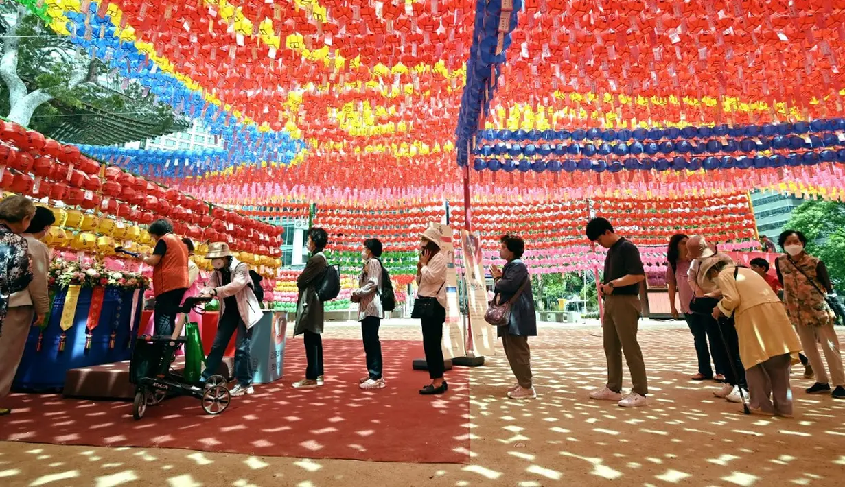 <p>Warga mengantre di bawah lentera teratai jelang perayaan ulang tahun Buddha di Kuil Jogyesa. (Jung Yeon-je/AFP)</p>