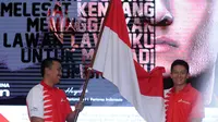 Rio Haryanto (kanan) menerima bendera Merah Putih dari Menpora Imam Nahrawi usai dipastikan bergabung dengan tim Manor Racing F1 di Jakarta, Kamis (18/2/2016). Rio akan mengikuti Formula 1 selama semusim penuh. (Liputan6.com/Helmi Fithriansyah)