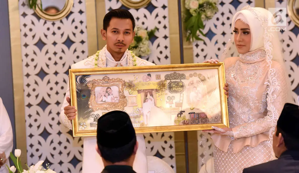 Pasangan Fairuz A Rafiq dan Sonny Septian menunjukan mahar usai melangsungkan akad nikah di kawasan Kuningan, Jakarta Selatan, Minggu (21/5). Sonny memberi mahar unik berupa uang tunai Rp 999.999. (Liputan6.com/Herman Zakharia)
