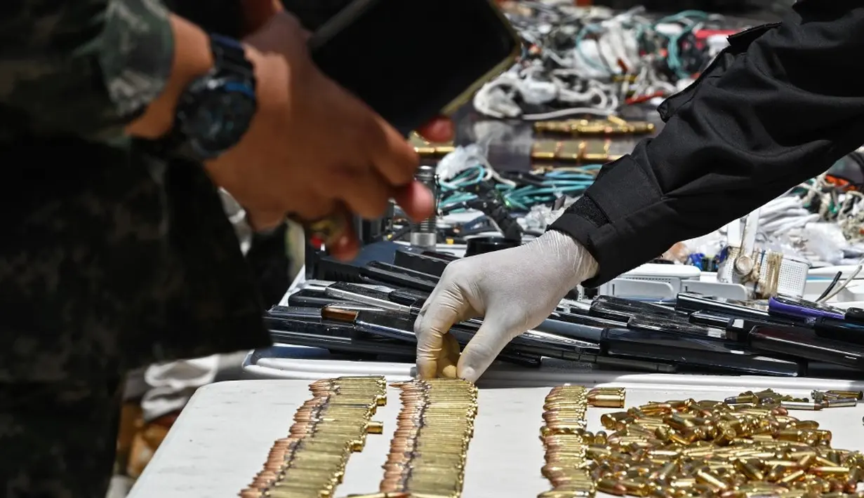 <p>Polisi Militer untuk Ketertiban Umum (PMOP) memamerkan senjata, amunisi, obat-obatan, ponsel, dan barang-barang lainnya yang disita selama operasi di Lembaga Pemasyarakatan Nasional Francisco Morazan. (Orlando SIERRA/AFP)</p>