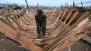 Tukang kayu Pakistan membuat kapal penangkap ikan di sebuah pelabuhan di Karachi (3/4). Pembuatan kapal buatan Pakistan menghasilkan ratusan kapal setiap tahun untuk memenuhi permintaan industri perikanan setempat. (AFP Photo/Asif Hassan)