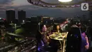 Pengunjung menyantap hidangan di Lounge in the sky, Jakarta, Selasa (29/3/2022). Lounge in the sky merupakan restoran dengan menyajikan sensasi menyantap hidangan dari atas ketinggian dengan pemandangan cakrawala 360 derajat Jakarta. (Liputan6.com/Herman Zakharia)