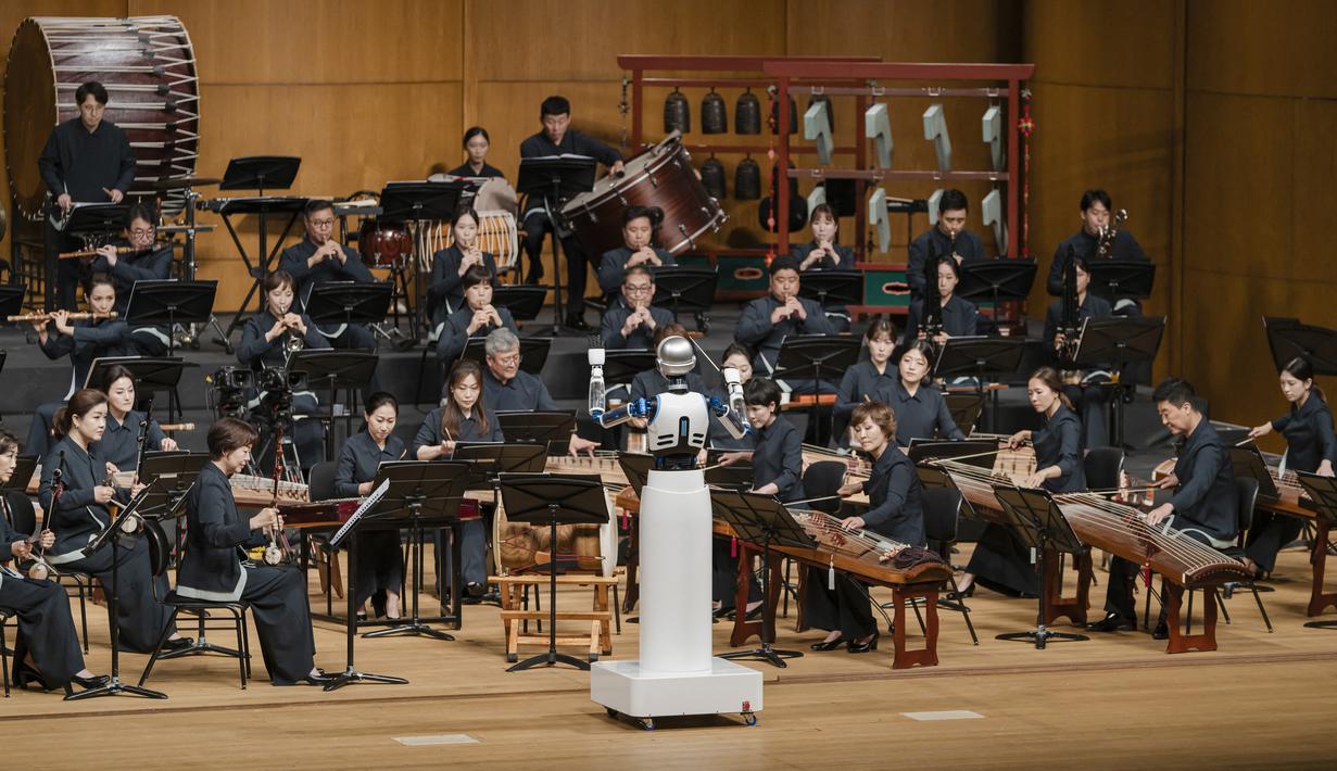 Diberi nama "EveR 6", robot setinggi lima kaki sepuluh inci (1,8 meter) ini memandu lebih dari 60 musisi Orkestra Nasional Korea yang memainkan alat musik tradisional Korea. (Photo by National Theater of Korea / AFP)
