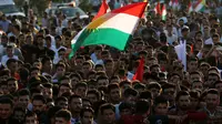 Warga Kurdi Irak berkumpul sambil mengibarkan bendera Kurdi saat melakukan aksi untuk meminta referendum kemerdekaan di Arbil, Irak utara (13/9). (AFP Photo/SAfim Hamed)