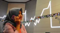Pengunjung melintasi layar pergerakan saham di Bursa Efek Indonesia, Jakarta, Jumat (10/2). (Liputan6.com/Angga Yuniar)