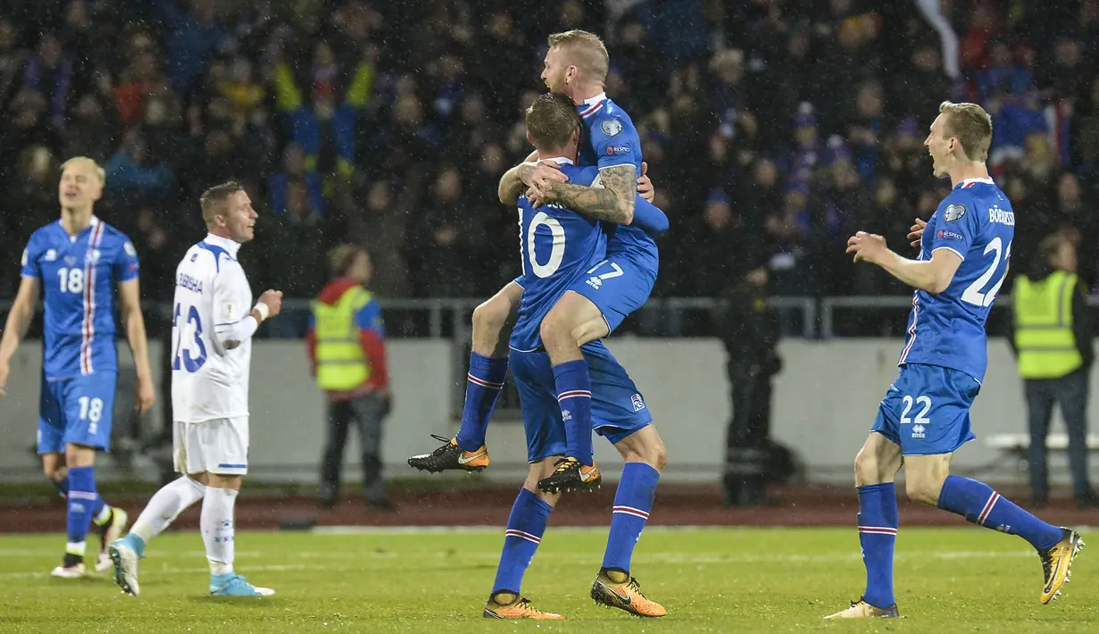 Para pemain Islandia merayakan keberhasilan lolos ke Piala Dunia 2018 usai mengalahkan Kosovo di Reykjavik, Senin (9/10/2017). Islandia untuk pertama kali dalam sejarah lolos ke Piala Dunia. (AFP/Haraldur Gudjonsson)