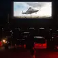 Puluhan mobil terparkir di depan layar bioskop saat pemutaran film drive-in di Family Drive-in di Virginia, 10 Agustus 2018. Menonton film di luar ruangan atau drive-in merupakan bagian penting dalam industri hiburan di Amerika. (AFP PHOTO/Nicholas Kamm)