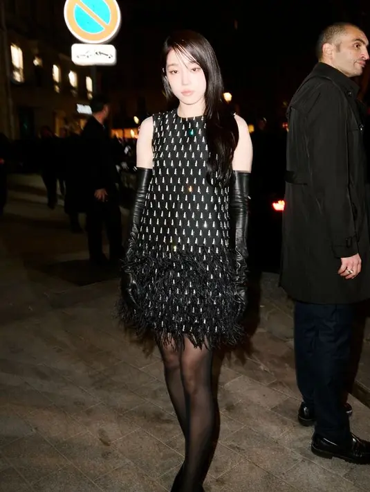 Salah satu tampilan yang mencuri perhatian datang dari Roh Yoonseo, yang tampil dalam balutan mini dress hitam bertekstur dengan detail feather di bagian hem. Dipadukan dengan gloves kulit panjang dan sheer tights.