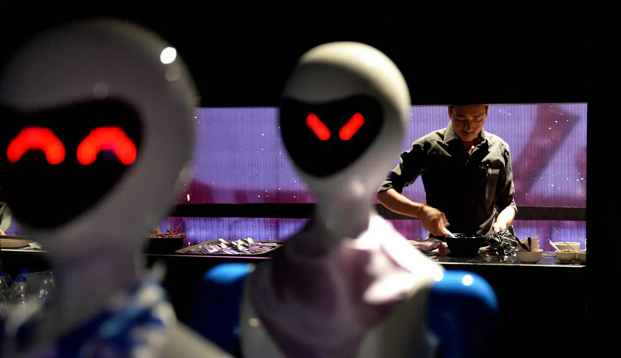 Koki menyiapkan makanan untuk dibawa oleh pelayan robot di Chennai, India (20/12). Restoran ini merupakan yang pertama di India yang memiliki pelayan robot dengan server otomatis membawa piring dari dapur ke pelanggan. (AFP Photo/Arun Sankar)
