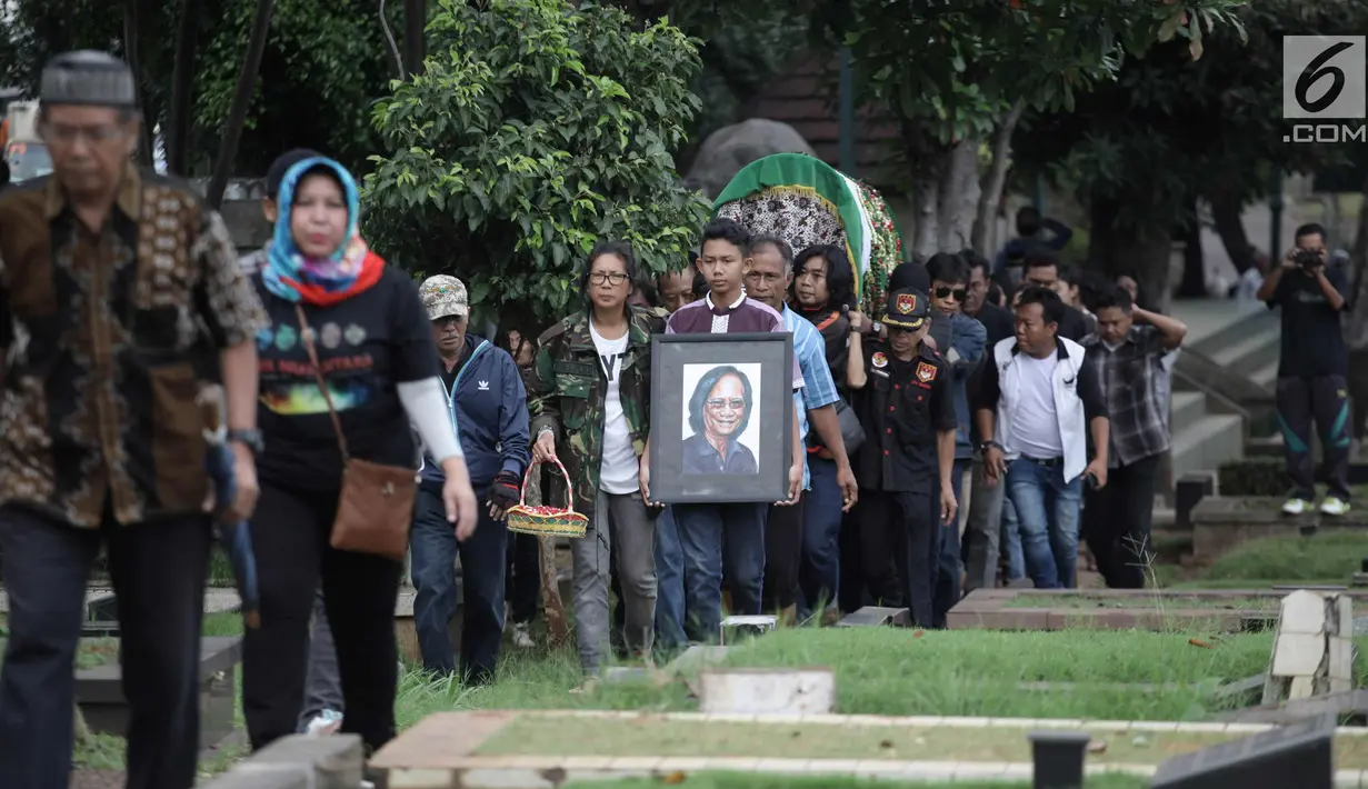 Sejumlah keluarga dan kerabat mengantarkan jenazah Vokalis grup band legendaris Koes Plus, Yon Koeswoyo untuk dimakamkan di TPU Tanah Kusir, Jakarta Selatan, Sabtu (6/1).  (Liputan6.com/Arya Manggala)