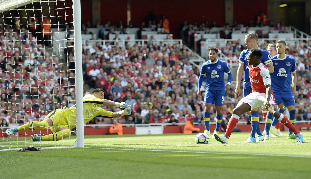 Kiper Everton, Joel Robles, berusaha menghalau tendangan striker Arsenal, Danny Welbeck  pada laga Premier League, di Stadion Emirates, Minggu (21/5/2017).  Arsenal menang 3-1. (EPA/Gerry Penny)