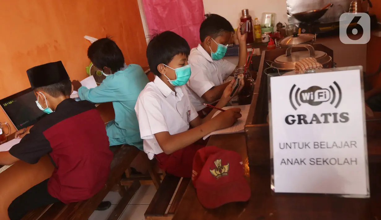Sejumlah siswa sekolah dasar belajar dengan menggunakan wifi gratis yang disediakan oleh warkop Rizki, di Pondok Aren, Tangerang Selatan, Rabu (29/7/2020). Wifi gratis disediakan untuk membantu anak anak sekitar yang tidak memiliki jaringan internet dan smartphone. (Liputan6.com/Angga Yuniar)