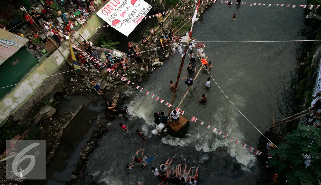 Sejumlah warga memadati bantaran Kali Code untuk menyaksikan lomba panjat pinang, Yogyakarta, Selasa (9/8). Lomba diselenggarakan untuk menyambut HUT RI ke-71. (Liputan6.com/Boy Harjanto)