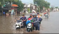 Jalur pantura Pasuruan-Surabaya, tepatnya Jalan Raya Tambakrejo Pasuruan, lumpuh total tidak bisa dilalui kendaraan akibat banjir. (Istimewa)