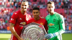 Zlatan Ibrahimovic, Jesse Lingard dan David De Gea berfoto bersama dengan Piala Community Shield di stadion Wembley, London, Inggris, (1/8). Gol Ibrahimovic menit ke 83 menjadi penentu kemengangan MU atas Leicester City. (Reuters/Andrew Couldridge)