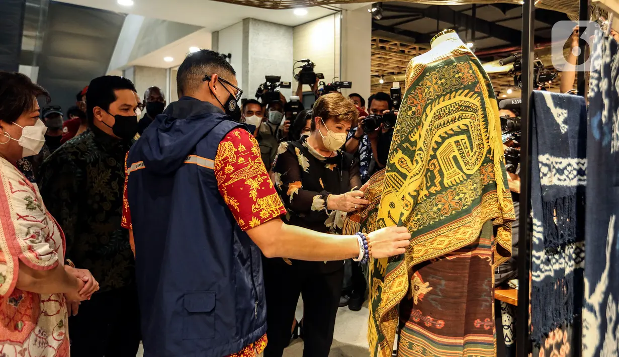 Direktur Pelaksana Dana Moneter Internasional (IMF) Kristalina Georgieva yang didampingi Menteri BUMN Erick Thohir bersama Menteri Pariwisata dan Ekonomi Kreatif (Menparekraf), Sandiaga Uno melihat produk-produk yang dijual saat mengunjungi Gedung Sarinah, Jakarta, Minggu (17/7/2022). (Liputan6.com/Johan Tallo)