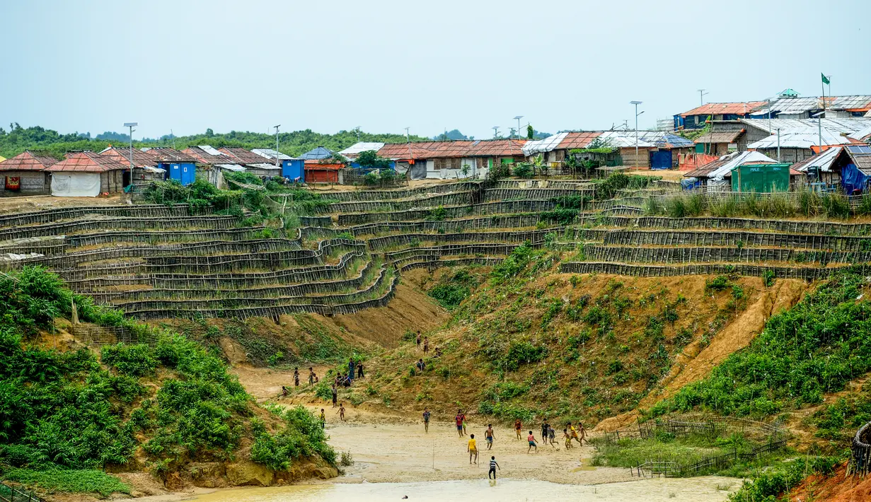 Anak-anak pengungsi Rohingya bermain sepak bola di Kamp Pengungsian Kutupalong, Ukhia, Bangladesh, Jumat (13/9/2019). Kamp ini didirikan secara tidak resmi pada tahun 1991 setelah ribuan orang Rohingya melarikan diri dari Operasi Pyi Thaya yang dilancarkan militer Burma. (MUNIR UZ ZAMAN/AFP)