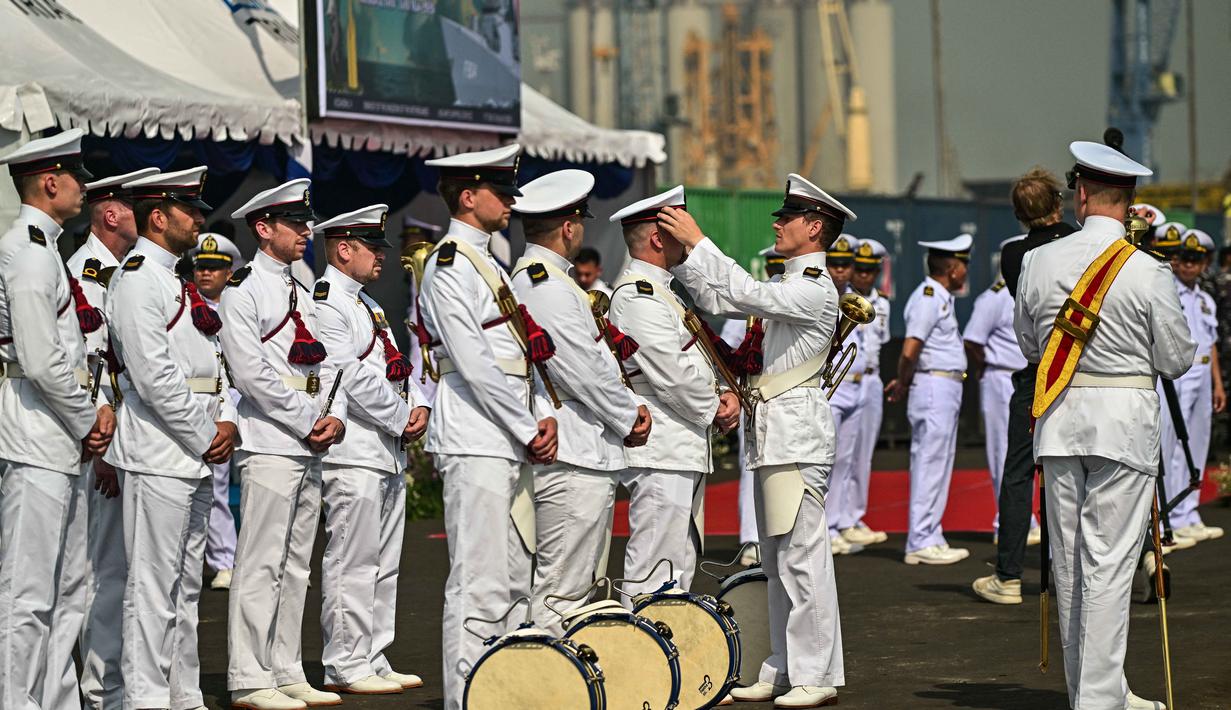 Para anggota Orkestra Marinir Belanda bersiap menyambut kedatangan kapal perang HNLMS De Ruyter di pelabuhan Tanjung Perak, Surabaya, Jawa Timur pada Kamis 14 Mei 2026. (JUNI KRISWANTO/AFP)
