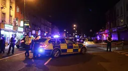 Petugas kepolisian menutup kawasan Finsbury Park di utara London usai insiden kendaraan yang menabraki pejalan kaki, Senin (19/6). Kepolisian Metropolitan London menyebut ada korban dalam insiden kendaraan yang menabraki pejalan kaki. (Yui Mok/PA via AP)