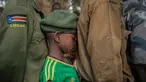 Seorang tentara anak yang baru dibebaskan menunggu dalam antrean di Yambio, Sudan Selatan, (7/2). Sebanyak 311 tentara anak-anak, termasuk 87 anak perempuan, telah dibebaskan oleh kelompok bersenjata di Sudan Selatan. (AFP PHOTO/Stefanie Glinski)