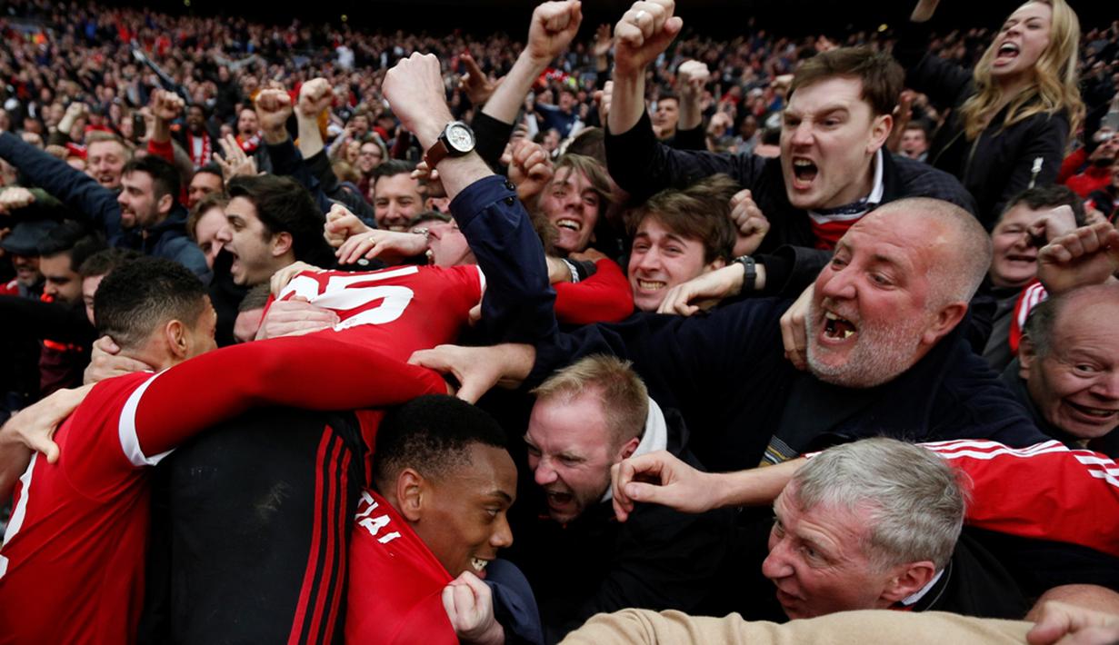 Suporter Manchester United menyambut Anthony Martial setelah mencetak gol kemenangan ke gawang Everton pada semifinal Piala FA di Stadion Wembley, London, Sabtu (23/4/2016). (AFP/Adrian Dennis)