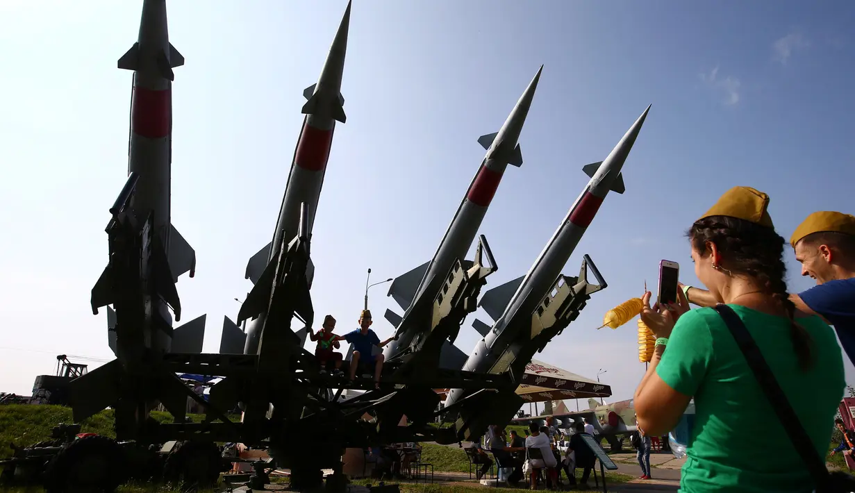 Anak-anak difoto oleh ibunya diatas rudal di Memorial "Stalin Line", dekat Desa Goroshki, Belarusia, (10/9). Selain pertunjukan pertempuran, di tempat ini juga banyak memamerkan alat-alat tempur Perang Dunia II. (Reuters/Vasily Fedosenko)