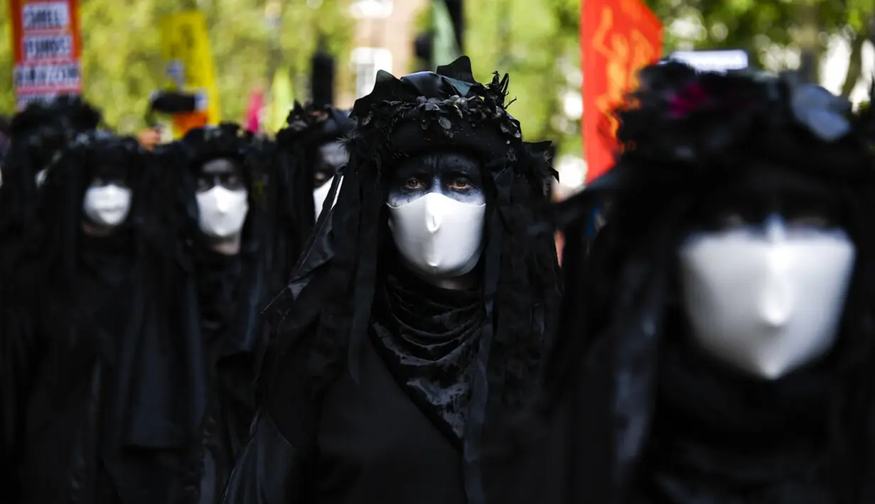 Aktivis Extinction Rebellion berbaris di sepanjang Parliament Street sebagai bagian dari protes perubahan iklim di London, Inggris, Selasa (8/9/2020). Menggelar aksi di tengah pandemi COVID-19, para aktivis mengenakan masker selama protes berlangsung. (AP Photo/Alberto Pezzali)