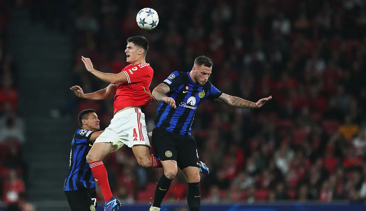 Bek Benfica #4 Antonio Silva (Kiri) dan penyerang Inter Milan #08 Marko Arnautovic melompat untuk mengejar bola dalam duel matchday 5 Grup D Liga Champions 2023/2024, di Estadio da Luz, Lisbon, Kamis (30/11/2023) dini hari WIB. (CARLOS COSTA / AFP)