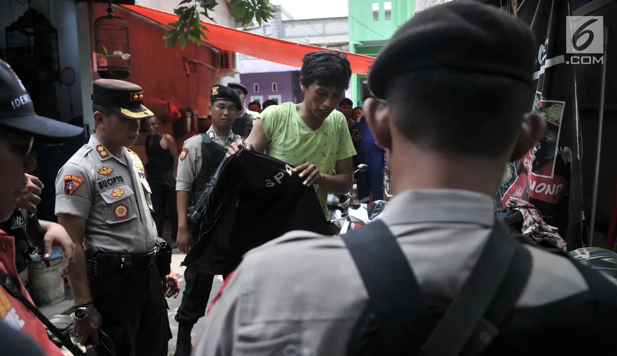 Keluarga terduga teroris diperiksa petugas kepolisian saat penggeledahan di kediaman orang tua tersangka di Jalan Belibis V, Semper Barat, Cilincing, Jakarta, Senin (23/9/2019). (merdeka.com/Iqbal S. Nugroho)