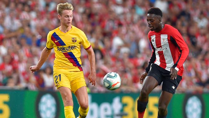 Striker Athletic Bilbao, Inaki Williams (kanan) membawa bola dari kejaran gelandang Barcelona, Frenkie de Jong selama pertandingan perdana La Liga Spanyol di Stadion San Mames, Sabtu (17/8/2019). Bilbao menang tipis atas Barcelona dengan skor 1-0. (AFP Photo/Ander Gillenea)