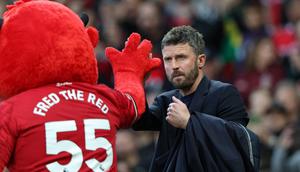 Pelatih sementara Manchester United asal Inggris, Michael Carrick (kanan), bertepuk tangan dengan maskot Fred the Red menjelang dimulainya pertandingan Liga Inggris antara Manchester United dan Brentford di Old Trafford, Manchester, barat laut Inggris, pada 28 April 2026. (Darren Staples/AFP)