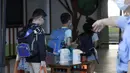 Siswa sekolah dasar mengenakan masker untuk melindungi diri dari penyebaran COVID-19 dan dan mendisinfeksi saat tiba di sekolah di Taipei, Taiwan, Rabu (1/9/2021). Seluruh sekolah di Taiwan kembali dibuka untuk tahun ajaran baru setelah ditutup akibat pandemi COVID-19. (AP Photo/Chiang Ying-ying)