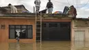 Warga berada di atas rumah menunggu evakuasi, Cali di Kolombia, Selasa (16/5). Banjir terjadi setelah hujan lebat dan menyebabkan meluapnya sungai Cauca. (AFP PHOTO / LUIS ROBAYO)