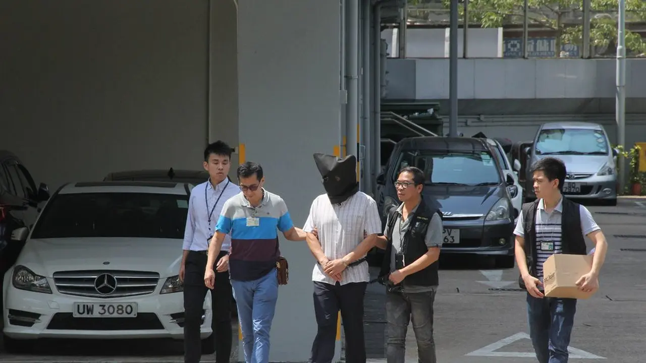 Dr Khaw Kim-sum, pelaku pembunuhan bola yoga, digiring oleh petugas kepolisian setelah menjalani sidang di Hong Kong, 20 September 2018 (AFP)