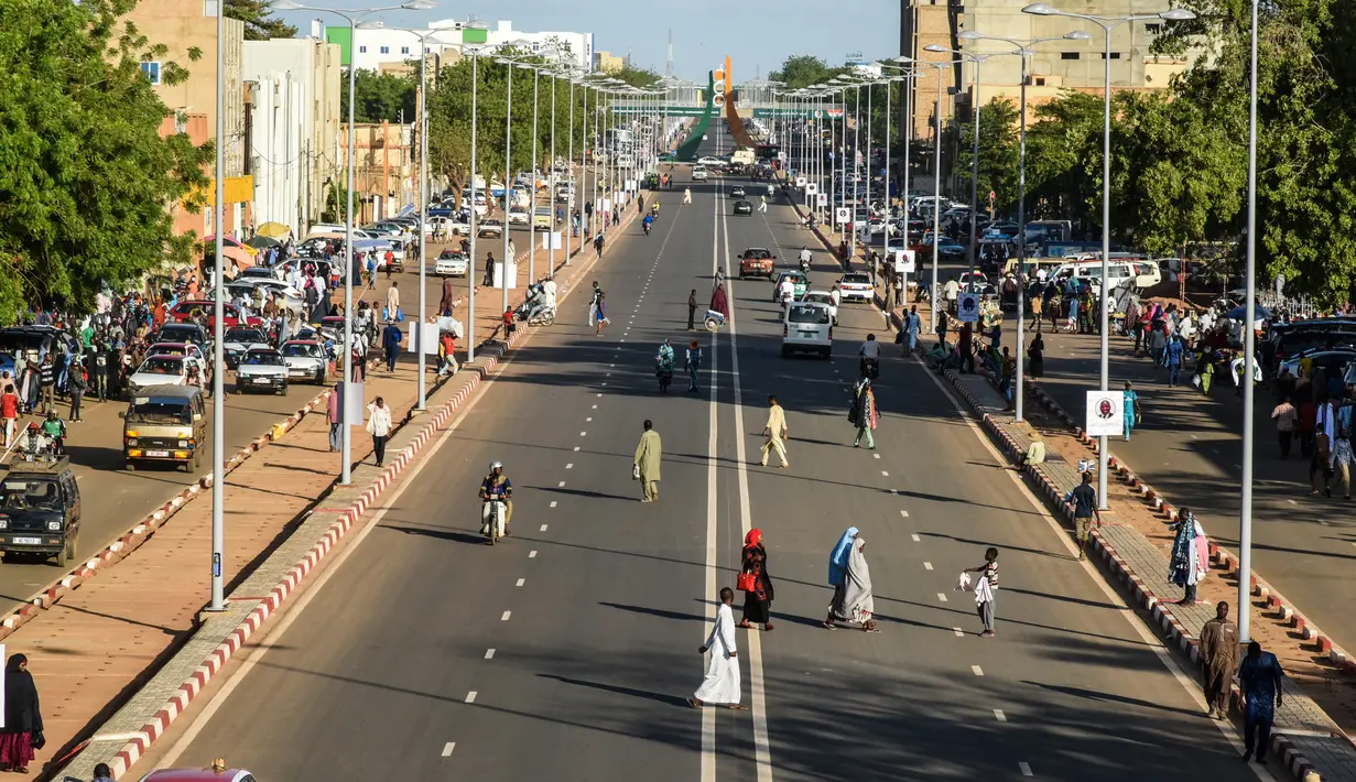 Orang-orang melintasi jalanan di Niamey, Niger (10/7/2019). Niamey adalah ibu kota sekaligus kota terbesar Niger. Penduduknya berjumlah 800,000 jiwa (2000) dengan luas wilayah 670 km².  (AFP Photo/Issouf Sanogo)