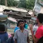 Warga mengamati sebuah bangunan yang roboh menyusul gempa 6,4 SR di Kabupaten Pidie Jaya, Aceh, Rabu (7/12). Sejumlah bangunan di Kabupaten Pidie Jaya rusak akibat gempa yang tak berpotensi tsunami tersebut. (Zian Muttaqien/AFP)