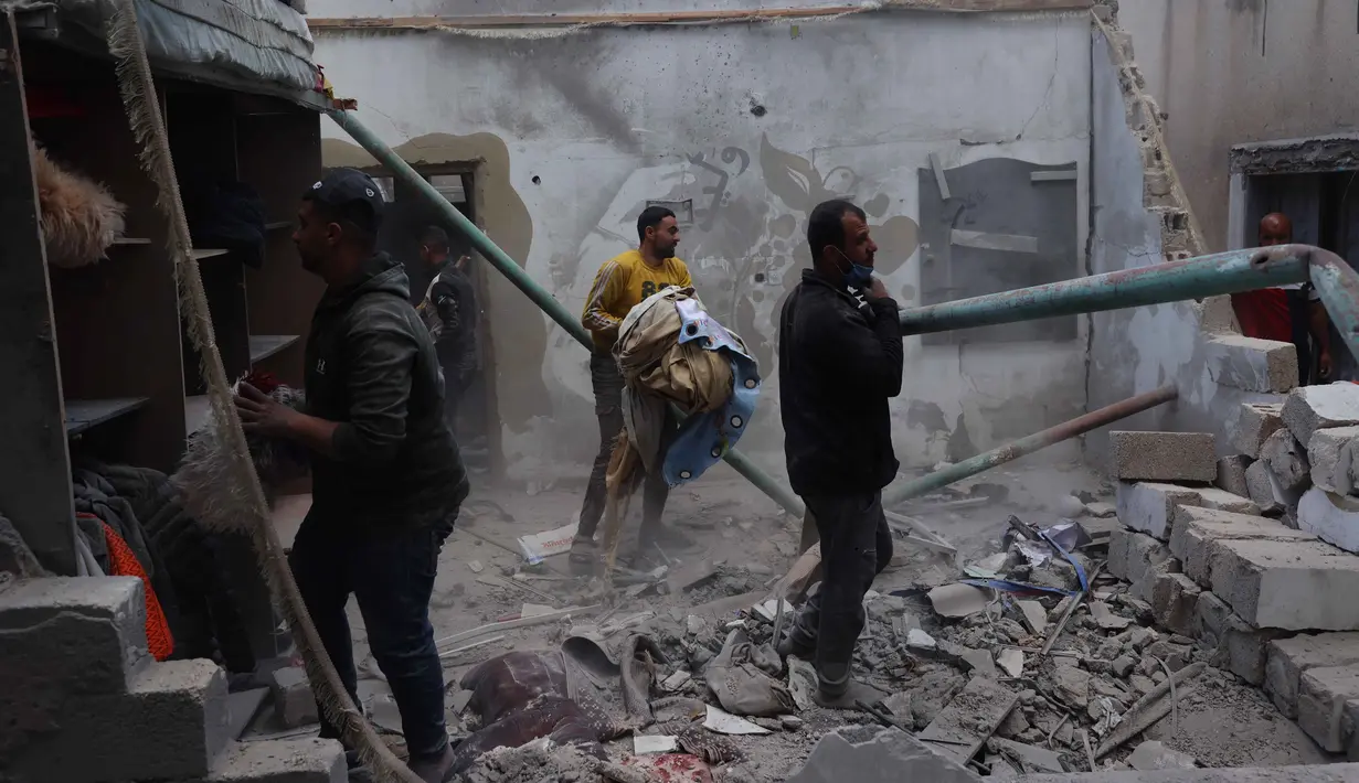 Warga Palestina yang mengungsi memeriksa kerusakan setelah sebuah rumah menjadi sasaran serangan Israel di kamp pengungsi Maghazi, Jalur Gaza Tengah pada Kamis 21 Mei 2026. (Eyad Baba/AFP)