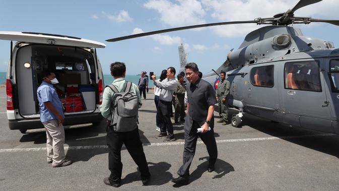 Petugas medis memuat sampel dari kapal pesiar MS Westerdam ke dalam helikopter untuk pengujian di Sihanoukville, Kamboja, Kamis (13/2/2020). Beberapa pejabat kesehatan Kamboja menuturkan bahwa sekitar 20 penumpang mengeluhkan sakit perut atau demam. (AP Photo/Heng Sinith)