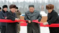 Pemimpin Korea Utara Kim Jong-un (kedua kanan) menggunting pita untuk menandai selesainya pembangunan Kota Samjiyon, Korea Utara, Senin (2/12/2019). Samjiyon merupakan sebuah kota baru yang dibangun di dekat Gunung Paektu. (STR/AFP/KCNA MELALUI KNS)