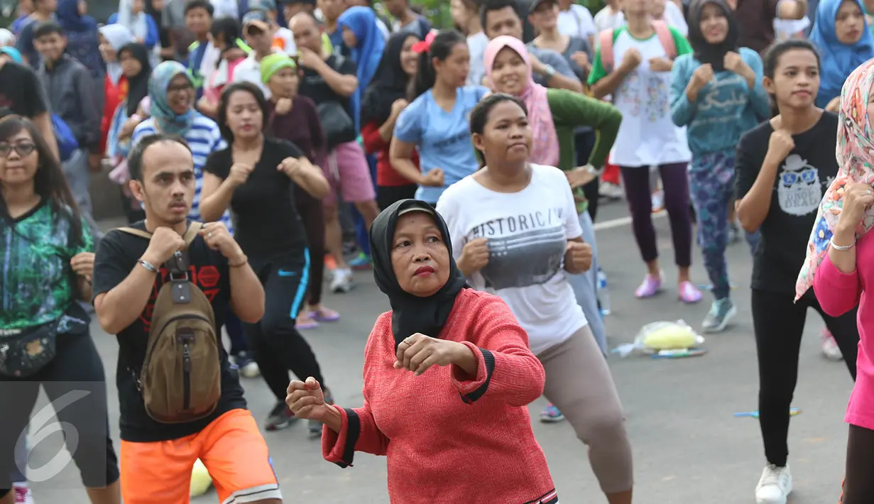 Peserta mengikuti kegiatan body combat di area CFD Jalan Jenderal Sudirman Jakarta Pusat, Minggu (14/5). Kegiatan tersebut dilakukan dalam rangka menyemarakkan Hari Pensiun Nasional yang diperingati pada 20 April 2017. (Liputan6.com/Immanuel Antonius)