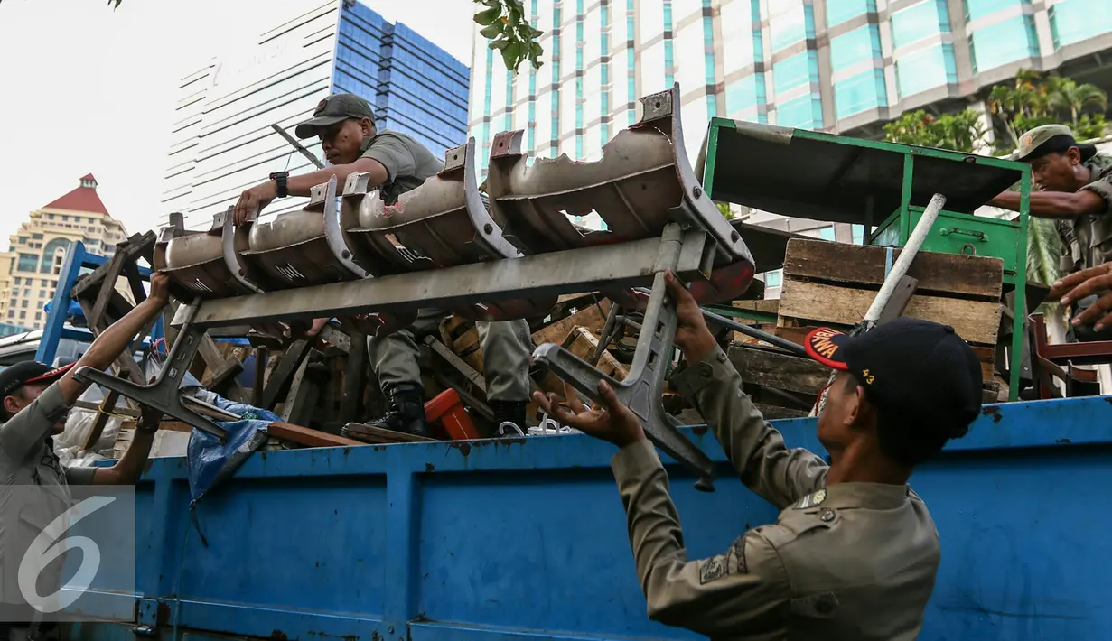 Petugas Satpol PP mengakut barang-barang PKL yang tetap nekat berjualan di trotoar, Jakarta, Selasa (29/3/2016). Puluhan Satpol PP gelar razia PKL yang nekat berjualan di trotoar di kawasan Senen, Jakarta Pusat. (Liputan6.com/Yoppy Renato)
