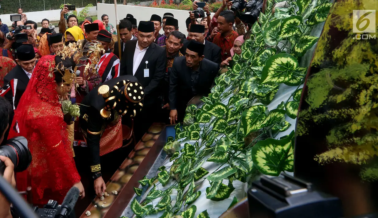 Pasangan Kahiyang Ayu dan Bobby Nasution saat mengikuti prosesi Pesta Adat di Bukti Hijau Regency, Taman Setia Budi, Medan, Sabtu, (25/11). Pengantin di upah-upah di tapian raya sebagai tanda lepasnya masa lajang. (Liputan6.com/Johan Tallo)