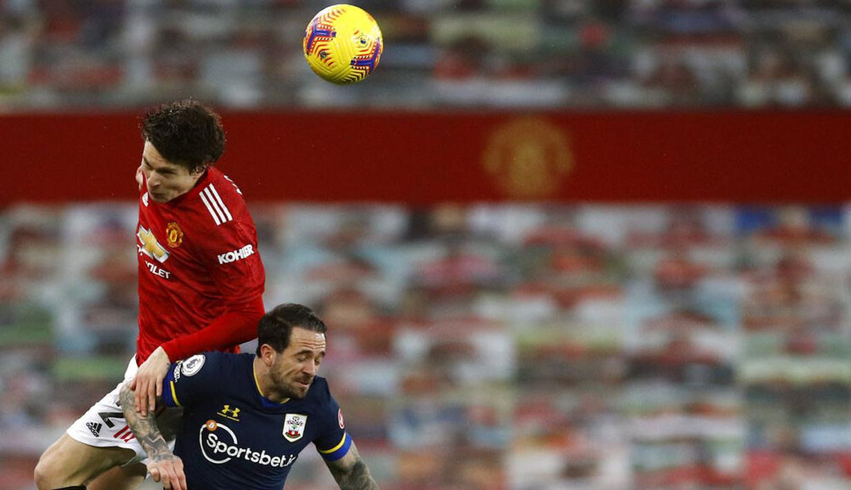 Bek Manchester United, Victor Lindelof, berebut bola dengan pemain Southampton, Danny Ings, pada laga Liga Inggris di Stadion Old Trafford, Selasa (2/2/2021). Setan Merah menang dengan skor 9-0. (Phil Noble/Pool via AP)