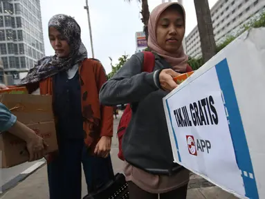 Karyawan Asia Pulp & Paper (APP) Sinar Mas membagikan takjil kepada pejalan kaki di kawasan Bundaran HI, Jakarta (24/6). (Liputan6.com/ Immanuel Antonius)