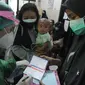 Petugas memberikan kartu vaksinasi kepada ibu hamil setelah disuntik vaksin covid-19 Sinovac di Puskesmas Jagakarsa II, Jakarta Selatan, Kamis (19/08/2021). Sudah dari pekan lalu sejumlah Puskesmas di DKI membuka vaksinasi covid-19 bagi ibu hamil. (merdeka.com/Arie Basuki)