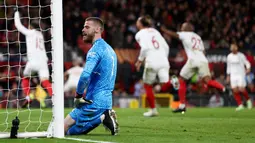 Kiper Manchester United, David de Gea, tampak kecewa setelah gawangnya dibobol pemain Sevilla pada leg kedua perempat final di Ramon Sanchez Pizjuan, Jumat (21/4/2023). Sementara David De Gea gagal mengantisipasi jatuhnya bola di luar kotak penalti sehingga terlepas dari kakinya. En-Nesyri mencuri bola dan dengan mudah menyarangkan ke gawang kiper MU itu. (AFP/Darren Staples)