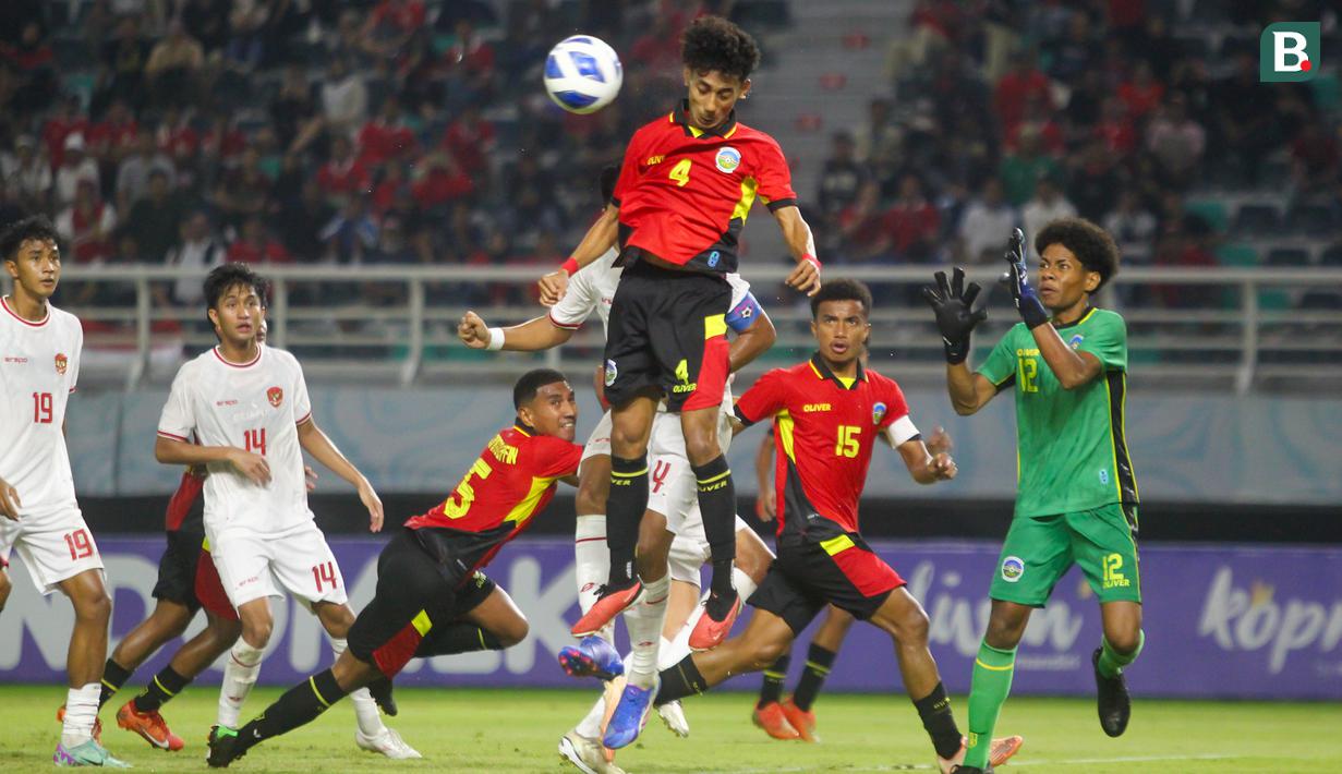 <p>Pemain Timnas Timor Leste U-19, Aureo Viera da Costa (tengah) melompat untuk menyundul bola saat menghadapi Timnas Indonesia U-19 Jens Raven pada laga matchday ketiga Grup A Piala AFF U-19 di Stadion Gelora Bung Tomo, Surabaya. Selasa (23/7/2024). (Bola.com/Aditya Wany)</p>
