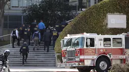 Petugas penegak hukum berjalan masuk ke dalam kantor pusat YouTube usai insiden penembakan di San Bruno, California, Amerika Selatan, Selasa (3/4). Polisi mengatakan tersangka yang identitasnya belum diketahui itu dilengkapi dengan pistol.  (AP/Jeff Chiu)